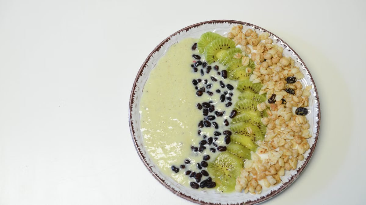 A vibrant kiwi smoothie bowl with nutritious toppings, perfect for a healthy meal.